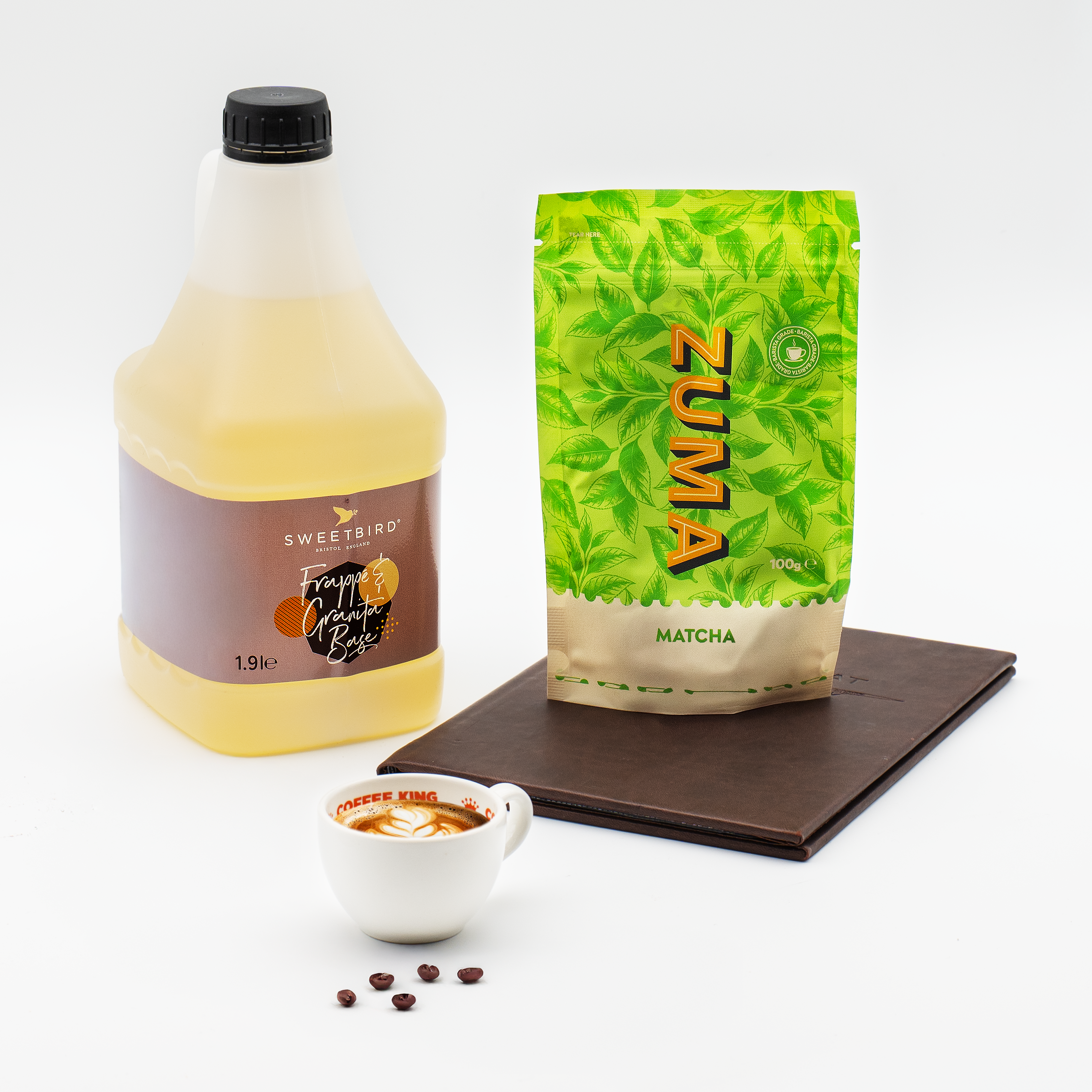 Bottle of Sweetbird product, Zuma matcha package, and a small cup with ingredients on a white background