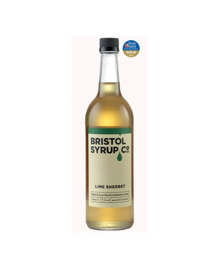 A bottle of Bristol Syrup Co Lime Sherbet syrup, featuring a cream-colored label with green and black text, a black cap, and a gold and blue award badge in the top right corner.