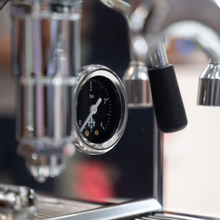 Close-up of a coffee machine with a pressure gauge