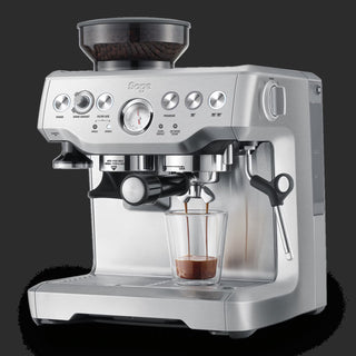 Silver Sage espresso machine with a glass of coffee on a black background
