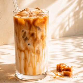 Iced caramel latte in a tall glass with caramel drizzle and caramel cubes, made using The Caramel Latte at Home Starter kit