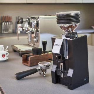 Eureka Mignon Zero AP 65 coffee grinder in black on a home coffee bar with espresso machine and portafilter